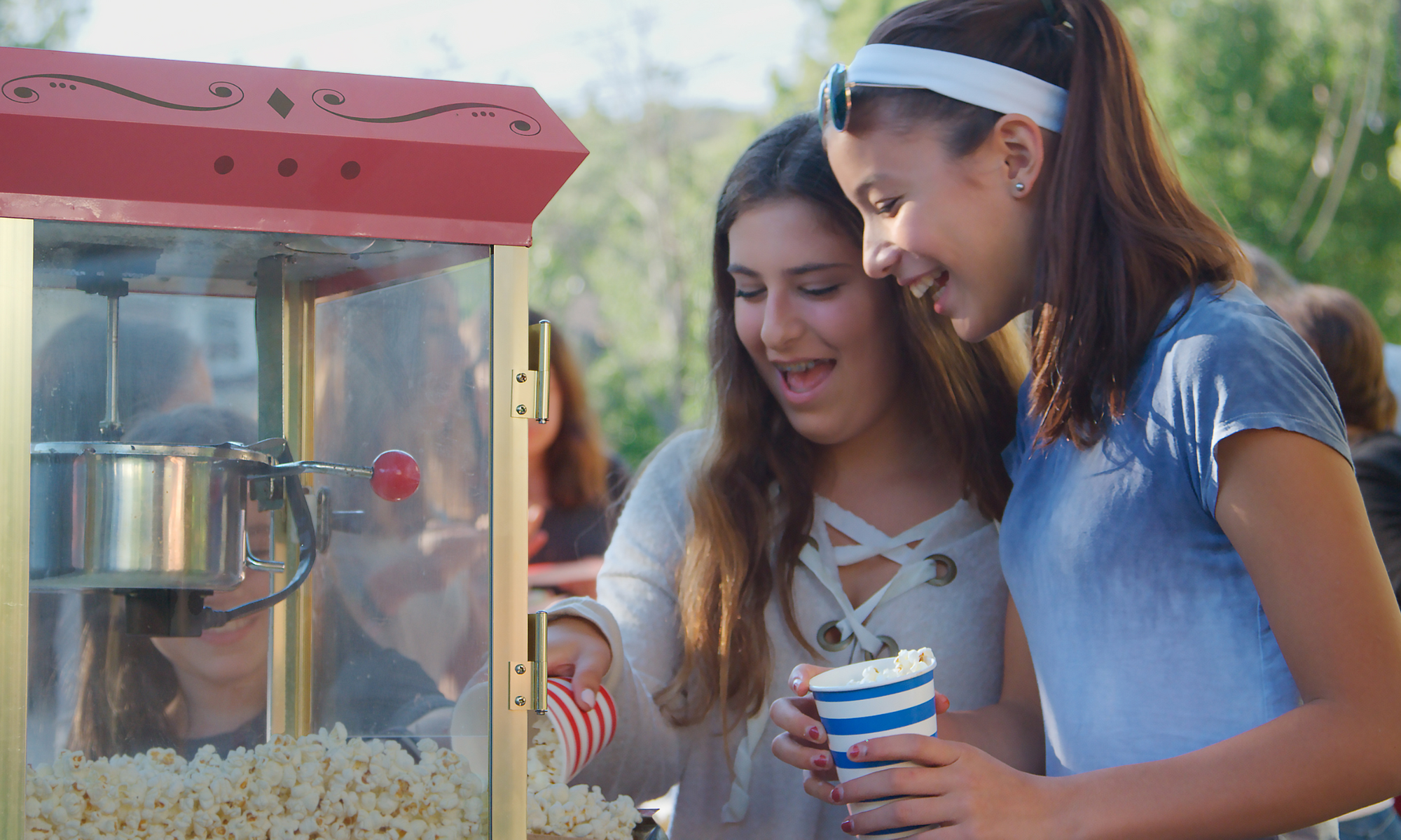 Two young girls enjoying Bytown Gourmet Classic Movie Theater popcorn at a community movie night