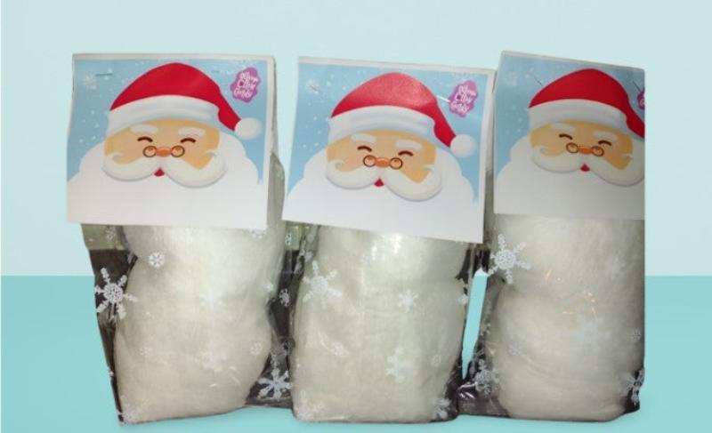 Three bags of white cotton candy that each have a paper topper with Santa's face and beard